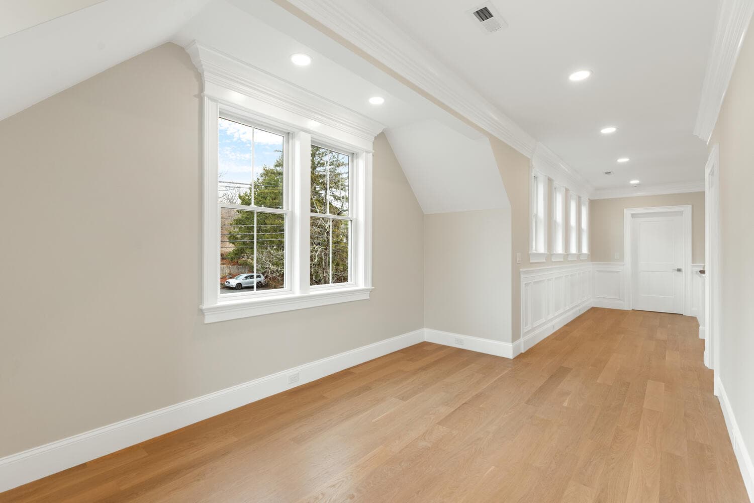 Second floor study with wainscoting panel walls and large Andersen windows