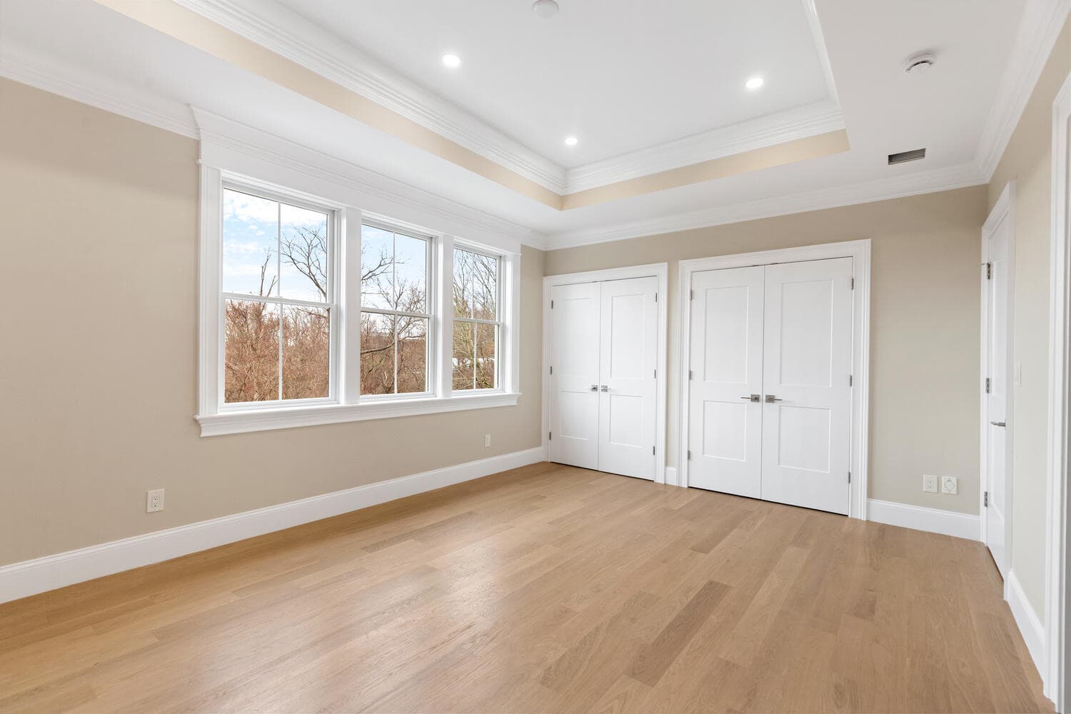 Second floor bedroom with tray ceiling, recessed lighting, and closet storage