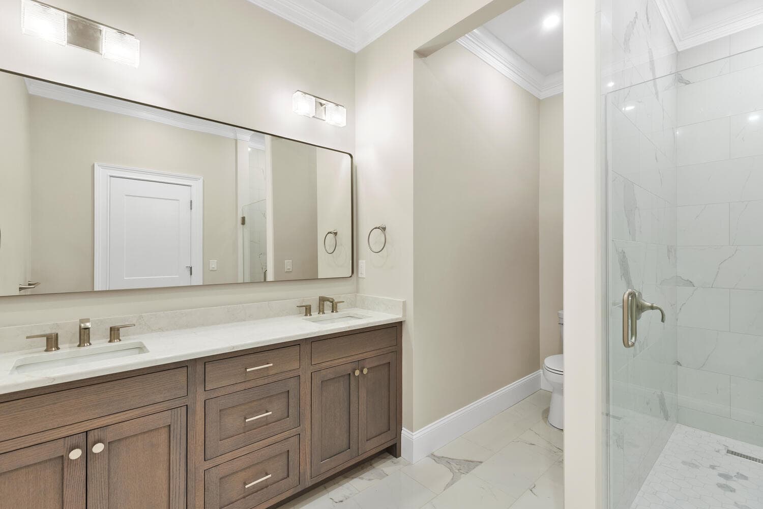First floor full bathroom with dual vanity, marble, and glass shower