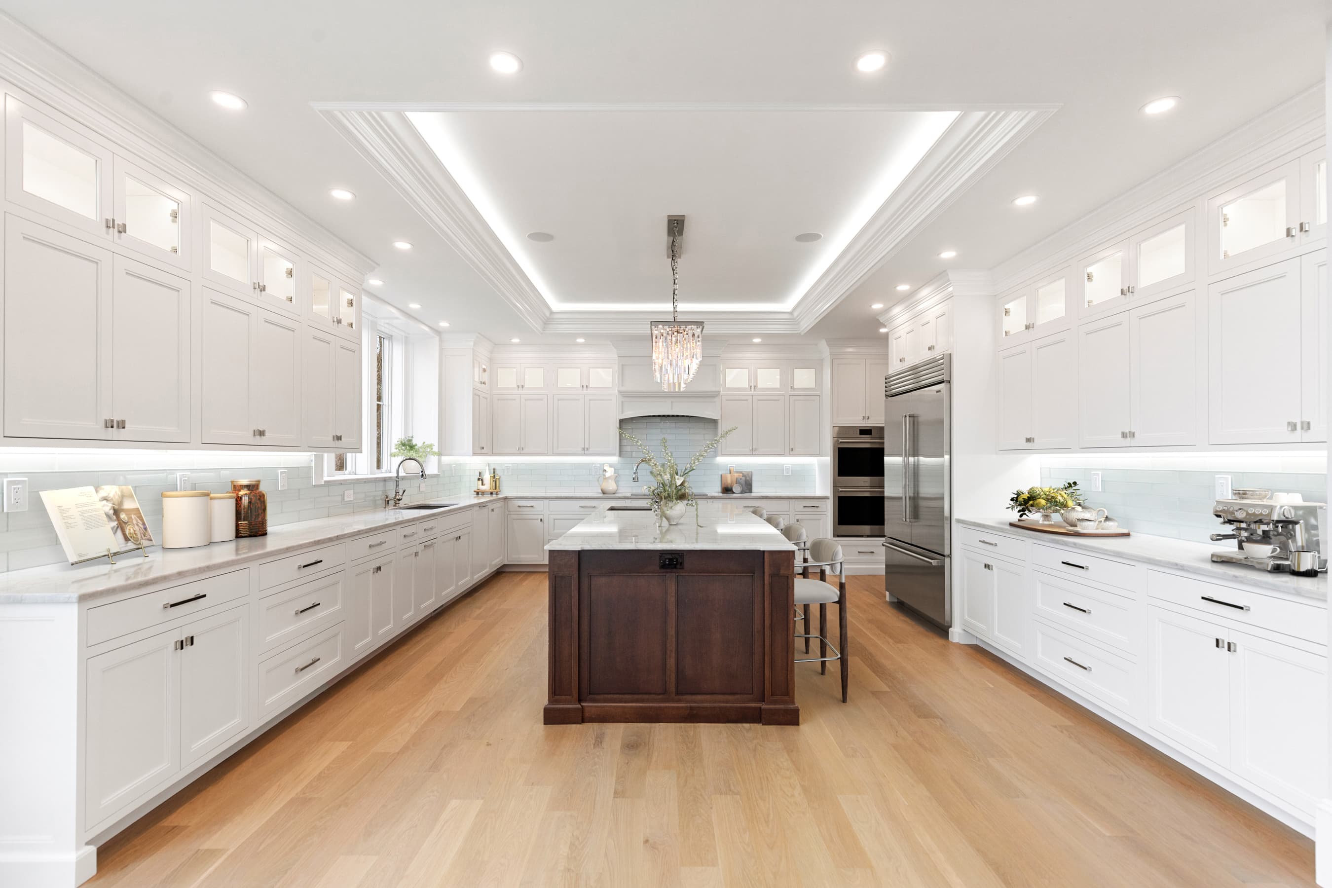 Grand kitchen with Crown Point cabinetry, cherry island, and crystal chandelier — virtually staged
