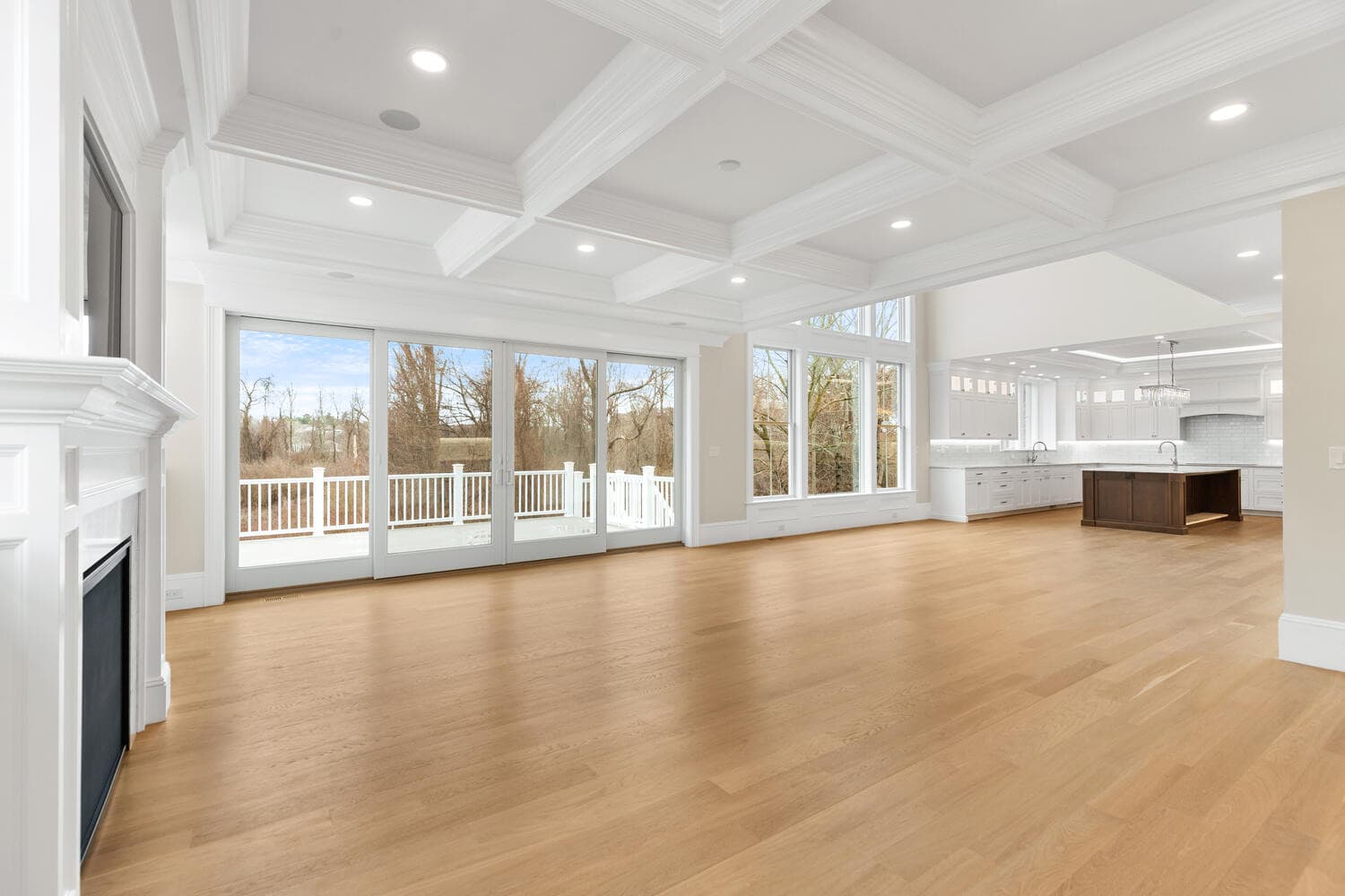 Living room with coffered ceiling, six-pane sliding glass doors to deck, fireplace, and built-ins