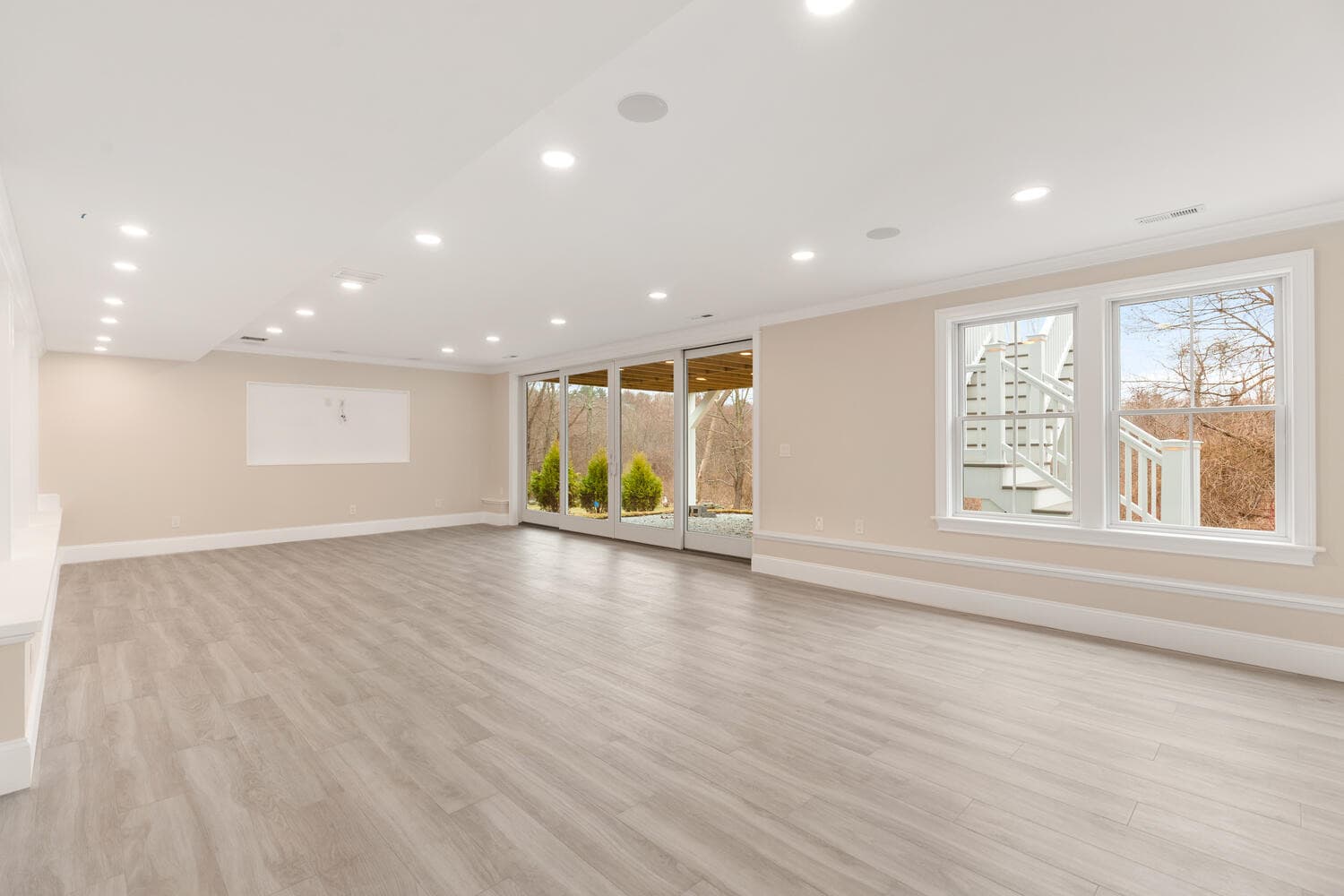Lower level recreation area with wood-look flooring and conservation views